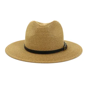 Detail view of the wide brim straw hat, showing delicate woven texture and black leather belt.