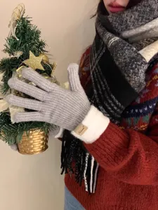 Detailopname gebreide handschoenen, warme winterwol met pluche manchet en decoratief item.