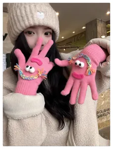 Cute quirky knitted gloves detail showcasing funny googly eyes and colorful braided hair.
