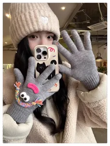 Cute quirky knit gloves with funny eyes and matching beanie hat, warm winter student fashion.