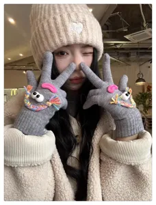 Close-up of quirky knit gloves with funny googly eyes and colorful details for winter.