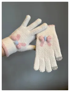 Detail view of women's winter warm touch screen knit gloves with cute pink blue bow design.