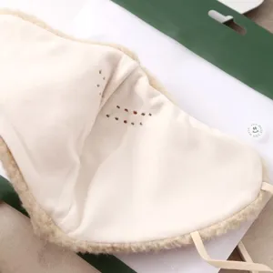 Primer plano de la mascarilla facial de felpa con textura suave y orificios de respiracion.