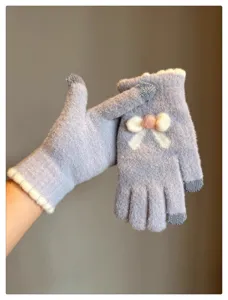 Close-up of knit touchscreen gloves with cute bow, soft wool material, winter warm details.