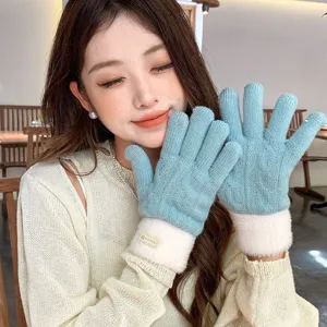 Close-up detail of winter women's warm knitted gloves with plush fleece cuffs and soft touch.