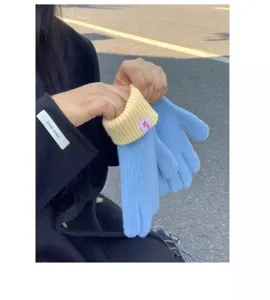 Detailed view of women's winter warm knitted touch screen gloves with cute contrast color cuffs.