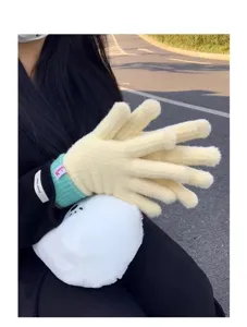 Detail shot of women's warm knitted touch screen gloves with cozy plush design for winter.
