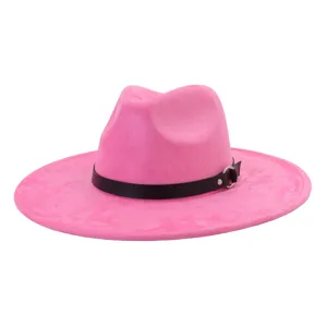 Detalle de sombrero fedora de ante rosa con tira de cuero negro y anillo metálico chic.