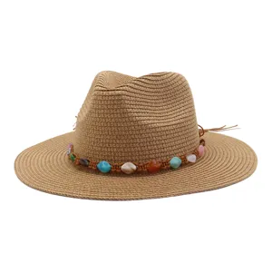 Detail du chapeau de paille avec large bord et perles de pierres precieuses colorees d'ete.