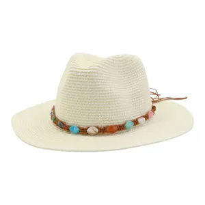 Gros plan détaillé d'un chapeau de paille avec une bande tressée colorée et des perles.