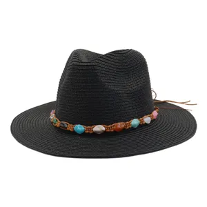 Détail chapeau de paille noir, grand chapeau de soleil avec bande tressée en pierres.