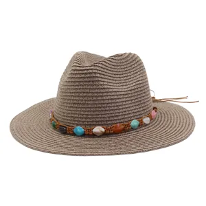 Vue détaillée du chapeau de paille à large bord avec bande tressée de perles colorées.