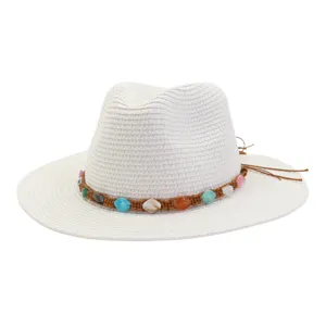 Vue détaillée du chapeau de paille blanc élégant doté d'une bande tressée en pierres.