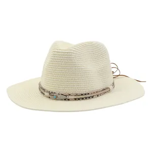 Detailweergave van de beige strohoed met een boho veren en turquoise steen decoratieve band.