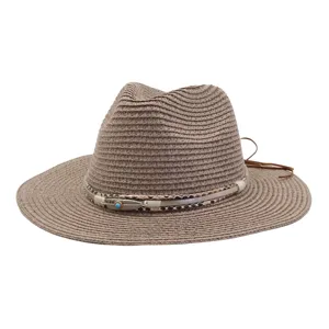 Gedetailleerd overzicht van bruine strohoed met stijlvolle verenband, perfect voor strand.