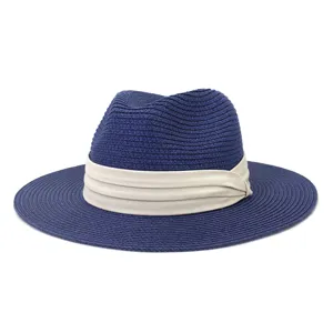Detail shot of the navy blue woven straw fedora hat with elegant beige pleated ribbon band.