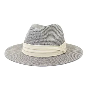 Detailed view of the grey straw fedora hat featuring a stylish beige fabric band design.