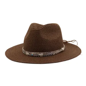 Bruine strohoed met brede rand en stijlvolle decoratieve band. Perfect voor het strand.