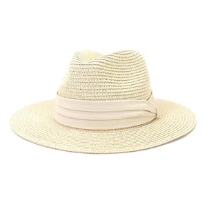 Close-up detail of beige straw fedora hat, classic woven texture and band trim accessory.