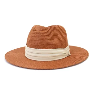 Detailed view of stylish straw fedora hat in caramel brown with elegant beige pleated ribbon.