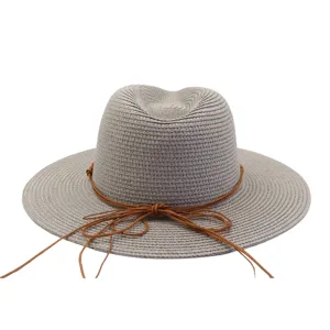 Vue détaillée du chapeau de paille gris avec lien marron, bord large pour l'été en plein air.