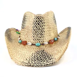 Detail de chapeau de cowboy en paille, motif peint avec bande de perles et de coquillages.