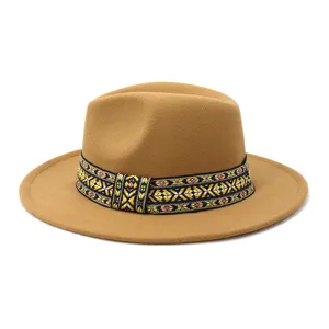 Primer plano de sombrero fieltro camello con banda tejida étnica colorida ala plana.