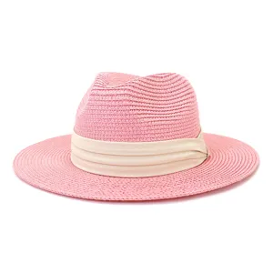 Detailed view of the pink straw fedora hat featuring a stylish beige ribbon band texture.