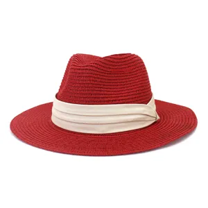 Red straw fedora hat detail view, stylish summer beach sun hat with beige ribbon band accessory.