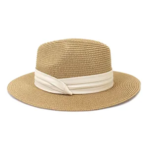 Straw sun hat detail view, woven summer fedora with white ribbon band, beach outdoor style.