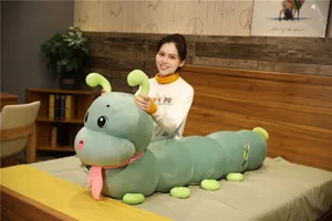 Cute green caterpillar plush long body pillow toy for kids sleeping companion in cozy bedroom.