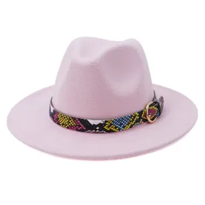 Vista detallada de sombrero fedora rosa con cinturón de piel de serpiente y hebilla metálica.