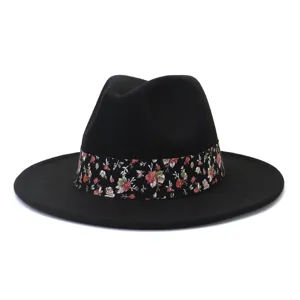 Primer plano detallado del sombrero fedora de lana negra con delicada banda floral.