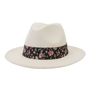 Sombrero fedora de lana blanco roto con cinta floral negra y ala plana ancha, vista detallada.