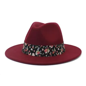 Vista detallada de sombrero fedora de fieltro rojo vino con elegante cinta floral negra.
