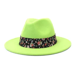 Primer plano del sombrero fedora de fieltro verde neón con elegante cinta floral negra.
