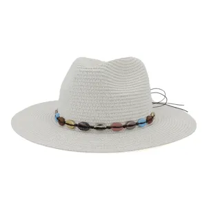 Détail chapeau de paille blanc avec bande de perles coquillages, protection solaire de plage.