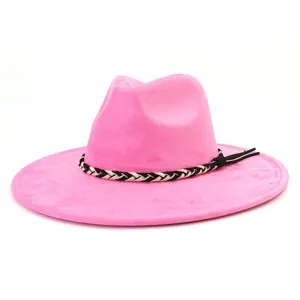 Gedetailleerd uitzicht op de roze suède fedora hoed met een stijlvolle zwart-witte gevlochten band.
