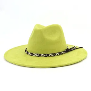 Detailweergave van de groene suède fedora hoed, brede platte rand, stijlvolle zwart witte vlecht.