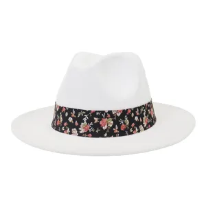 Vista detallada del sombrero fedora de lana blanca con cinta floral negra y ala plana.