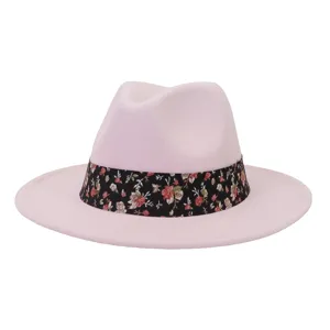Vista detallada de un sombrero fedora de lana rosa claro con elegante cinta floral negra.