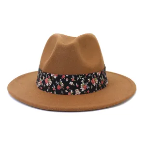 Detalle de primer plano del sombrero fedora de lana marrón con cinta floral negra.