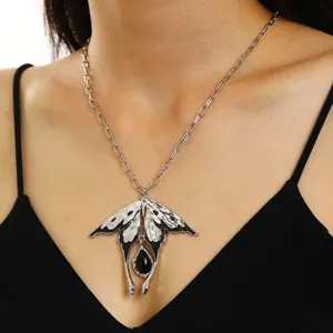 Collier pendentif oiseau avec émail noir et pierre en gros plan sur un mannequin