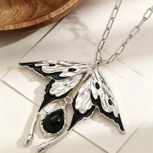 Gros plan détaillé d'un collier pendentif papillon argenté avec pierre noire goutte