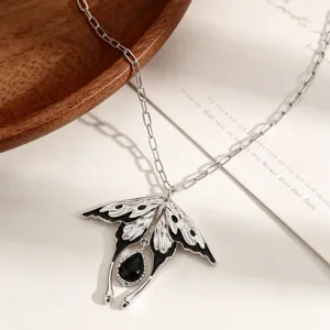 Vue détaillée du collier avec pendentif d'aile d'oiseau argenté et pierre noire.