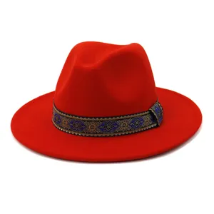 Gedetailleerd aanzicht van een rode wollen vilt fedora hoed met etnische geweven band.