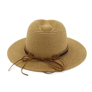 Detailed close-up of woven straw fedora hat featuring a stylish brown leather band bow.