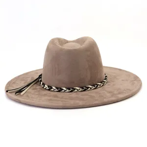 Detail van faux-suede fedora hoed met een chique zwart-witte gevlochten band en stijlvolle kwastjes.