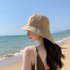 Vue de détail d'un chapeau de soleil beige élégant, parfait pour les vacances d'été à la plage.