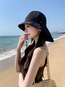 Vue détaillée d'un chapeau de soleil noir à large bord pour les vacances à la plage.